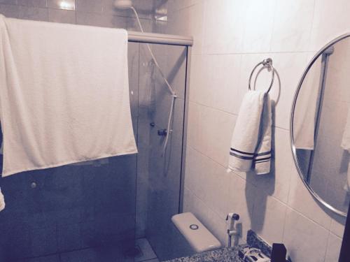 a bathroom with a shower with a sink and a mirror at Praia das Dunas Residence Club in Cabo Frio
