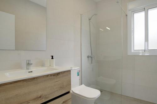 ein weißes Badezimmer mit Toilette und Waschbecken in der Unterkunft Casa Sofia in Roche