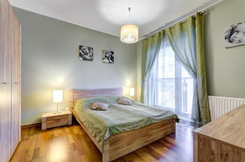 グダニスクにあるApartament Koga Waterlaneのベッドルーム1室(ベッド1台、大きな窓付)
