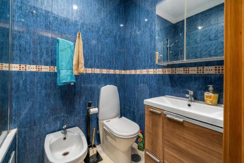 a blue bathroom with a toilet and a sink at Apartamento Belmar in Armação de Pêra