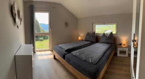 a bedroom with a bed and a large window at Landhaus Steinrose in Bodensdorf