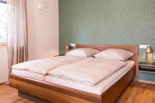 a bed with white sheets and pillows in a room at Ferienwohnung Anneliese in Neukirch