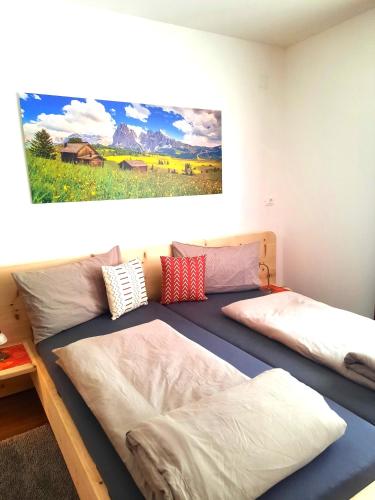 a bedroom with two beds and a painting on the wall at Peter Paul Domblick Erdgeschoss in Appiano sulla Strada del Vino