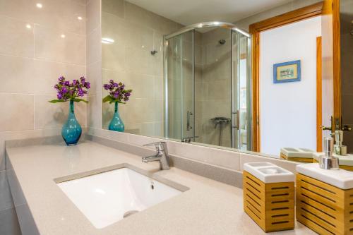 a bathroom with a sink and a vase of flowers at Apartment La Veleta with Sea View in El Port
