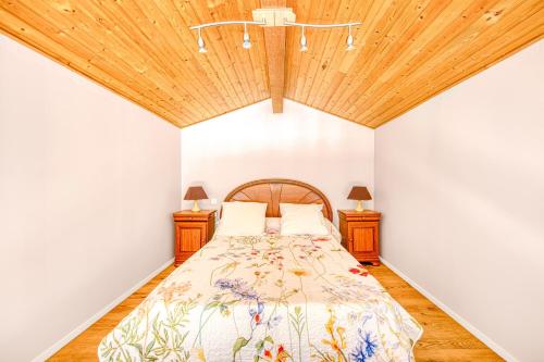 a bedroom with a bed with a wooden ceiling at Entre Vignobles Et Océan in Queyrac
