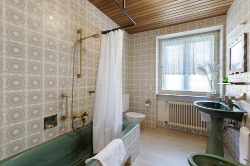 a bathroom with a tub and a sink at Donau-One in Beuron