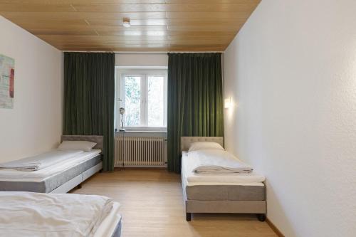 a room with three beds and a window at Donau-One in Beuron