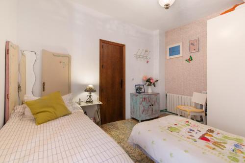 a bedroom with two beds and a table with a chair at La Rana Verde de Arriba in Los Romeros