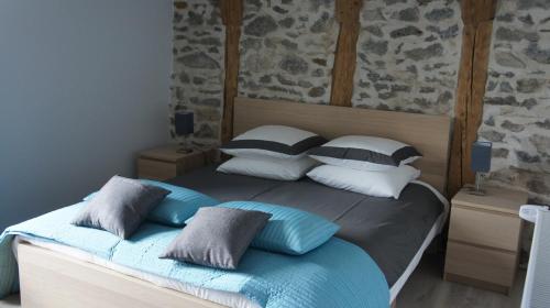 a bedroom with a bed with blue and white pillows at La Trouverie in Laqueuille