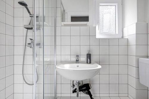 a white bathroom with a sink and a shower at Bei der alten Keksfabrik in Hamburg
