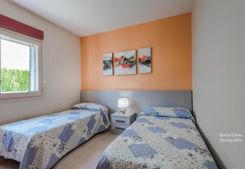a bedroom with two beds and a window at Villa 100 m from the beach in Roda de Bará
