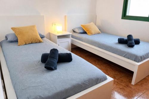 two beds in a room with black towels on them at Kalendra Jable in Guatiza