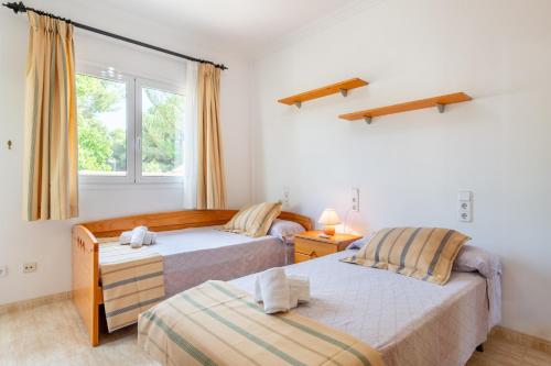 a bedroom with two beds and a window at Lago y Playa in Port d'Alcudia