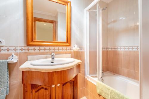 a bathroom with a sink and a mirror and a tub at Lago y Playa in Port d'Alcudia