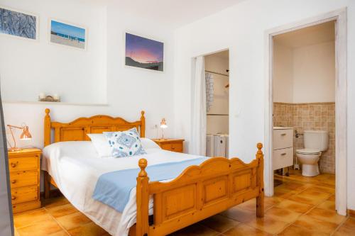a bedroom with a wooden bed and a bathroom at Apartamento Can Jaume in Artá