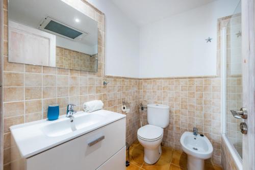 a bathroom with a toilet and a sink and a mirror at Apartamento Can Jaume in Artá