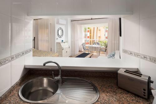 a kitchen with a sink and a view of a living room at Estudios 79 in Torrox