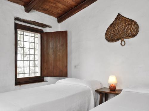 a bedroom with two beds and a window at Finca Fiori 1 in Is Molas 