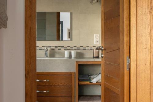 a bathroom with a sink and a wooden door at Villa Helychrisa in Aléria