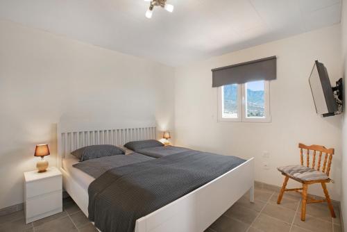 a bedroom with a bed and a chair and a window at Fewo Arafo in Güimar