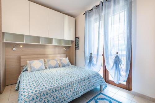 a bedroom with a bed and a large window at Appartamento Isabel in Villasimius
