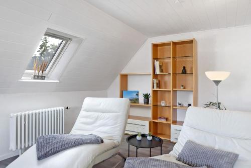 a living room with a white chair and a window at Ferienwohnung en Verde in Felsberg