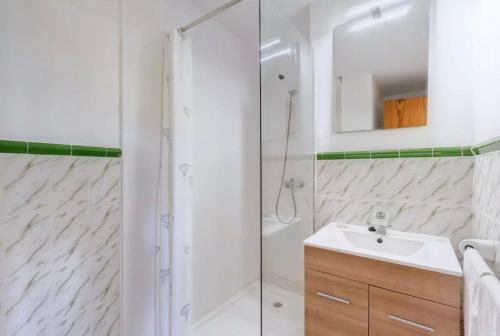 a white bathroom with a shower and a sink at La Cabanya Apartment 3d in Canyamel