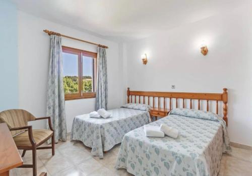 a bedroom with two beds and a window at La Cabanya Apartment 3d in Canyamel