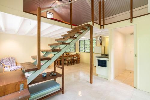 a kitchen and dining room with a spiral staircase in a house at Harmony Creek - The Cottage in Cow Bay