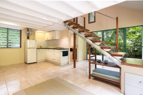 a kitchen with a spiral staircase in a house at Harmony Creek - The Cottage in Cow Bay
