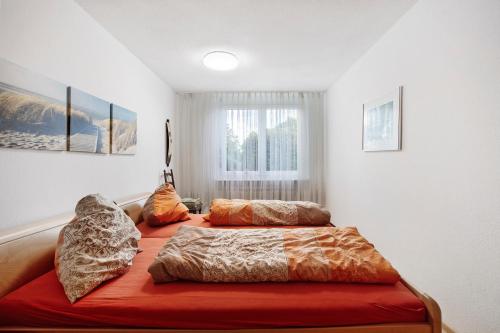 a bedroom with two beds with pillows and a window at Fewo Waldfee in Höchenschwand