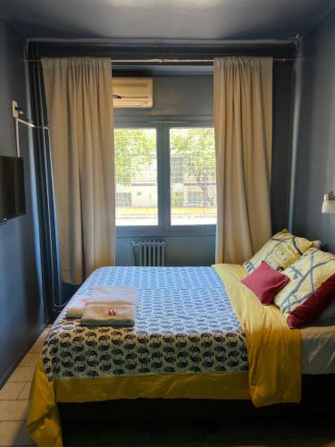 a bedroom with a bed in front of a window at Hotel Windsor Mendoza in Mendoza