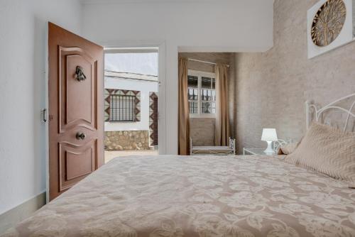 a bedroom with a large bed and a door at Piso Río de Conil in Conil de la Frontera