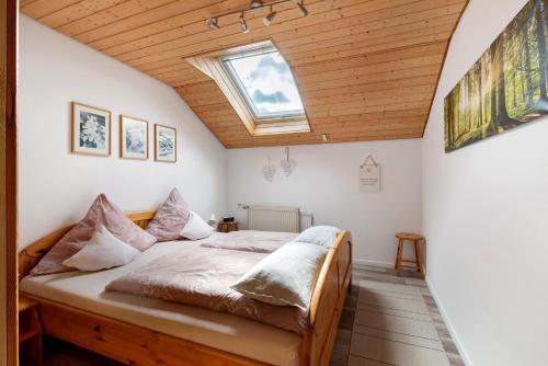 a bedroom with a bed with a skylight at Haus Müller in Böhringen