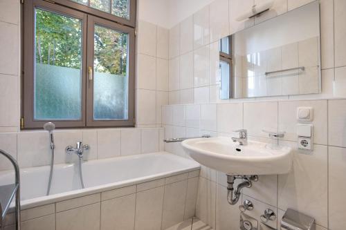a white bathroom with a sink and a bath tub at Effi-Briest-Villa in Heringsdorf