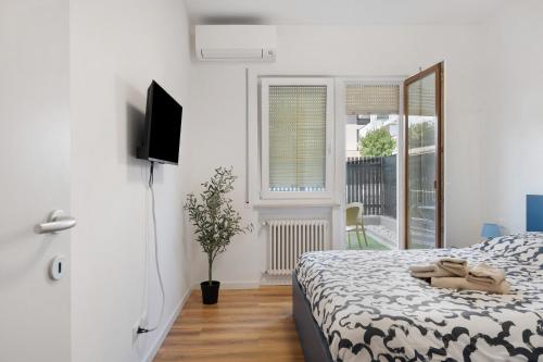 a bedroom with a bed and a tv and a window at Honey Home With Parking in Laives