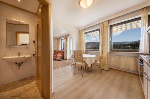 a kitchen and dining room with a table and a sink at Residence Kronstein - Fewo 3 in Tesimo