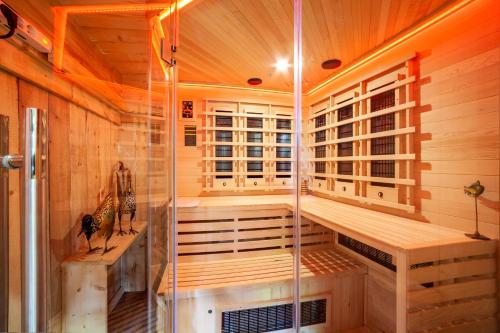 a sauna with a shower in a wooden cabin at Ferienhaus Rauchegg - Bergblick in San Pancrazio dʼUltimo