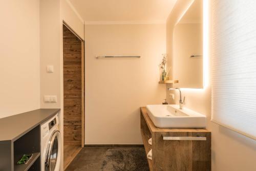 a bathroom with a sink and a washing machine at Apartment Roderer in Völs am Schlern