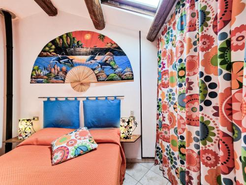 two beds in a room with a painting on the wall at Il Borgo 4 in Capoliveri