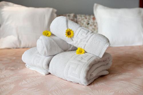 a stack of towels on a bed with yellow flowers at Carmelo y Carmela 5 in Teror