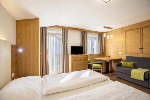 a hotel room with a bed and a living room at Rosalpina Apt 1 in San Vigilio Di Marebbe
