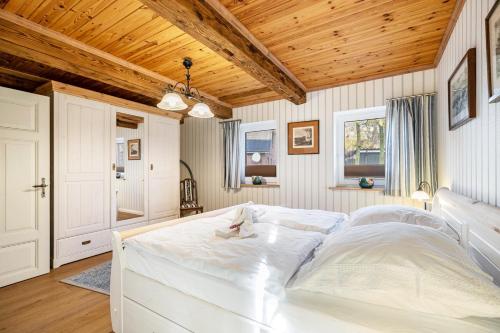 a large white bed in a room with wooden ceilings at Hof Diederichs in Bohmstedt