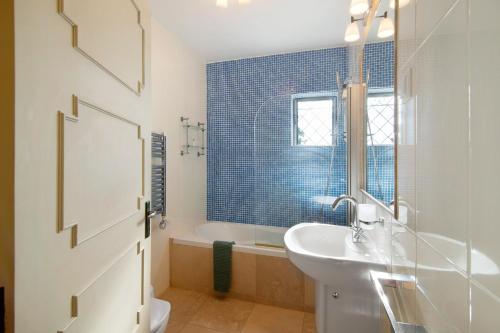 a bathroom with a white sink and a tub at Casa Allan in Vale do Lobo