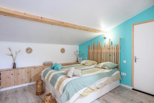 a bedroom with a large bed with blue walls at Studio proche Marais Poitevin in Oulmes