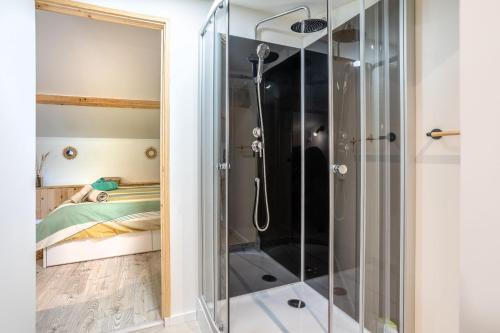 a glass shower in a bedroom with a bed at Studio proche Marais Poitevin in Oulmes