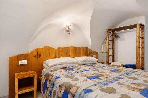 a bedroom with a large bed with a wooden headboard at Logge dei Paroloti Paolo in San Lorenzo in Banale