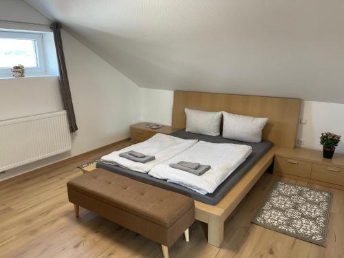 a bedroom with a bed with a bench and a window at promedklinik apartment 3 in Volkach