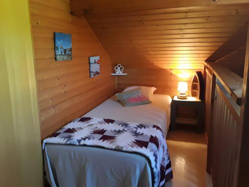 a bedroom with a bed in a wooden cabin at Maison de vacances Proche Arcachon in La Teste-de-Buch