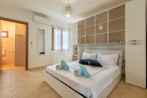 a bedroom with a large bed with towels on it at Villa Felicità in Sorso